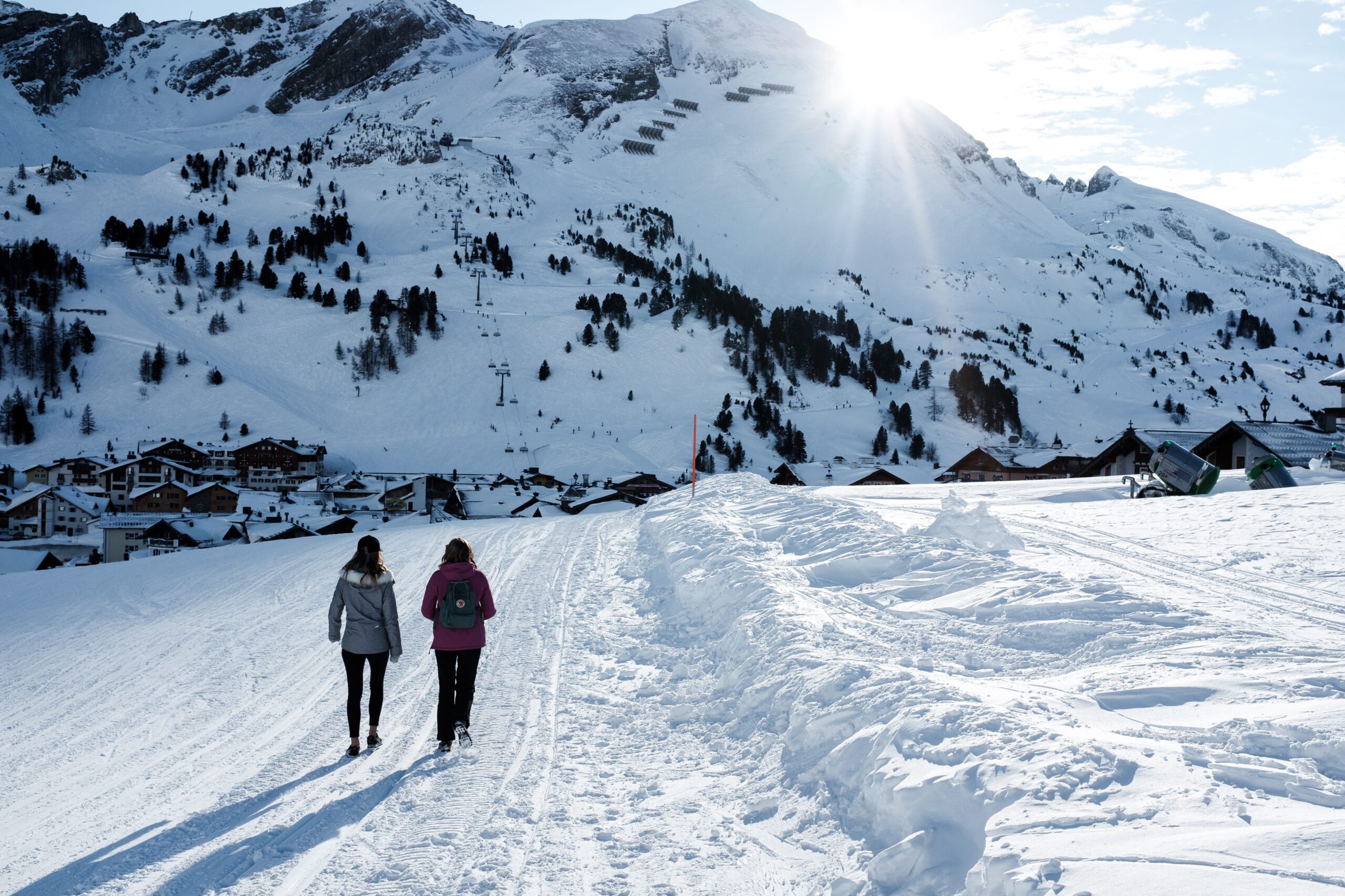 two people walking snow covered mountain
