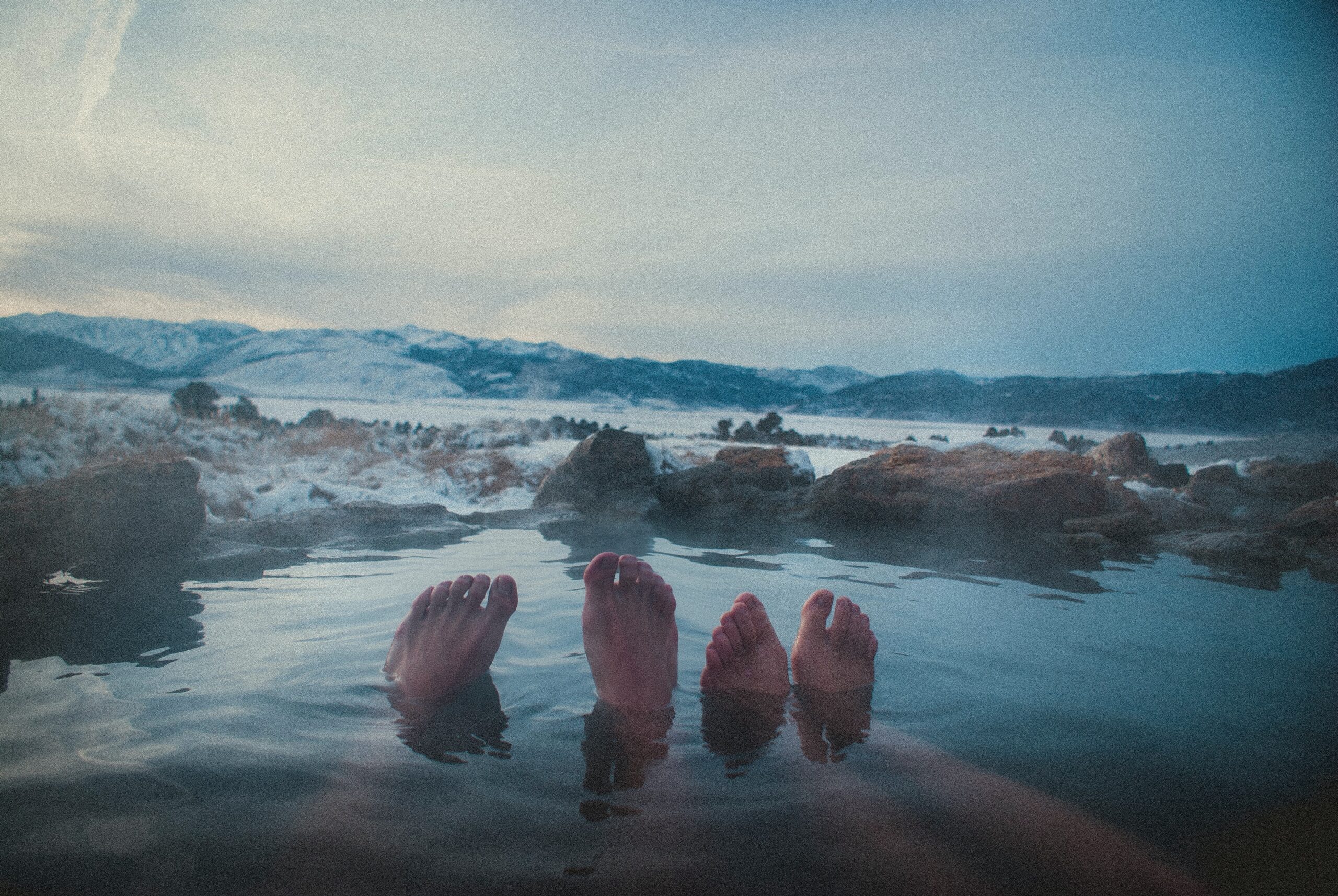feet poking out of hot springs pool
