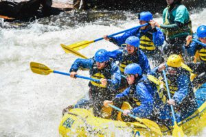 group intensely paddling into the river's spray