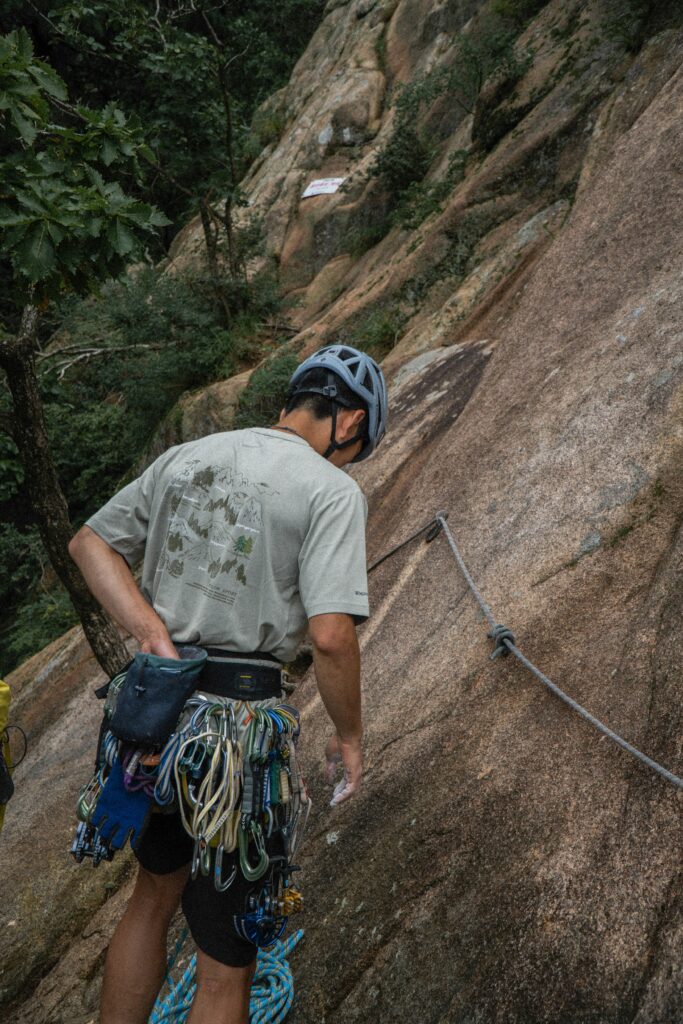 man with rock climbing carabiners and ropes