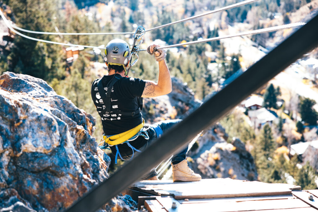 guide swinging off zipline platform