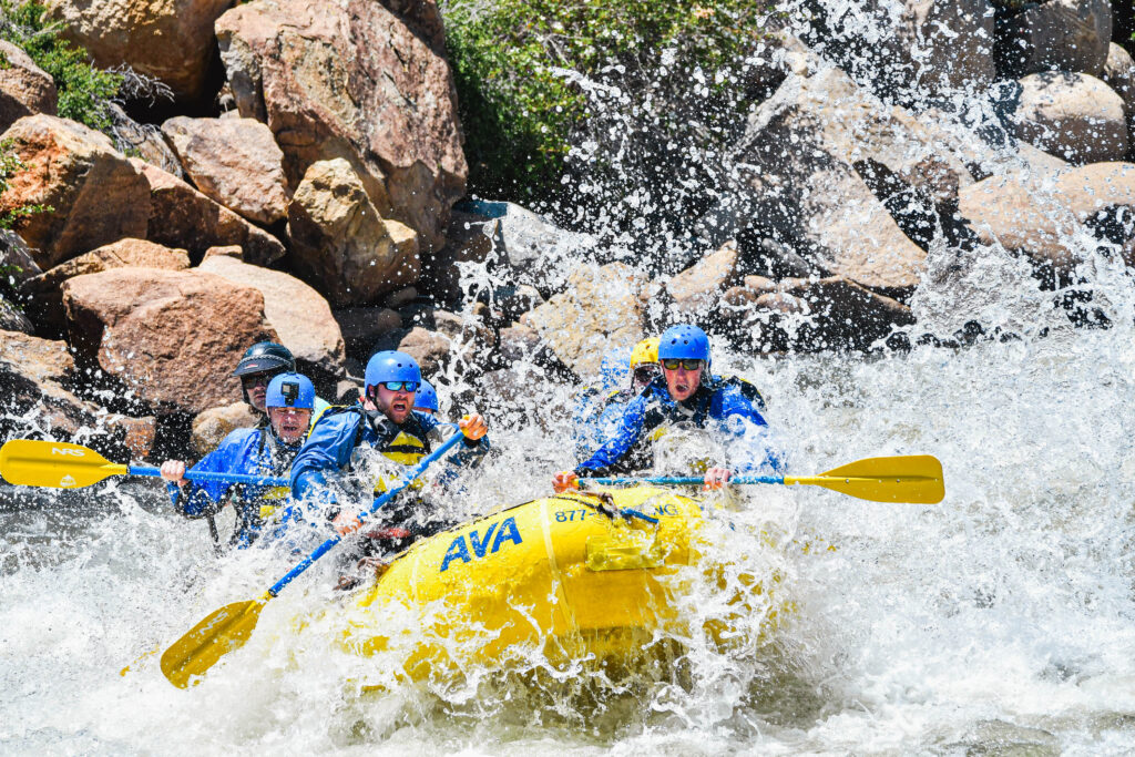 group paddling straight into oncoming spray