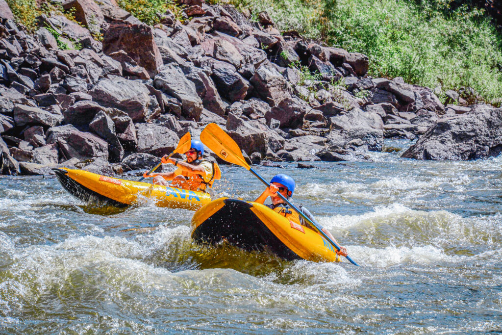 two men paddling inflatable kayaks