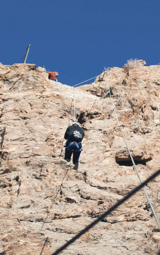 Person climbing a cliff face.