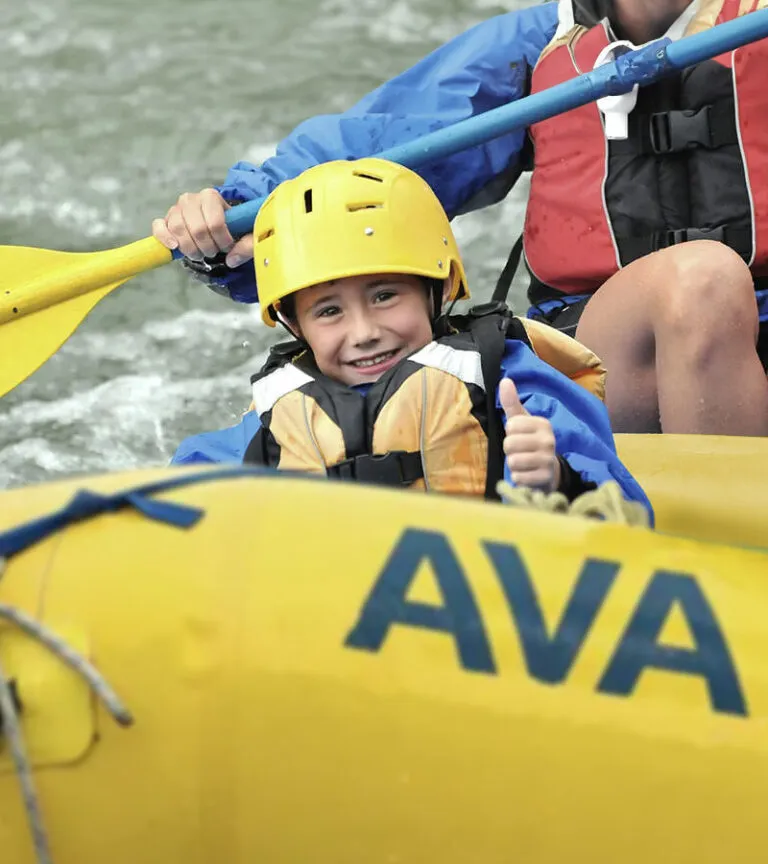 Kid giving the thumbs up sign from his raft.