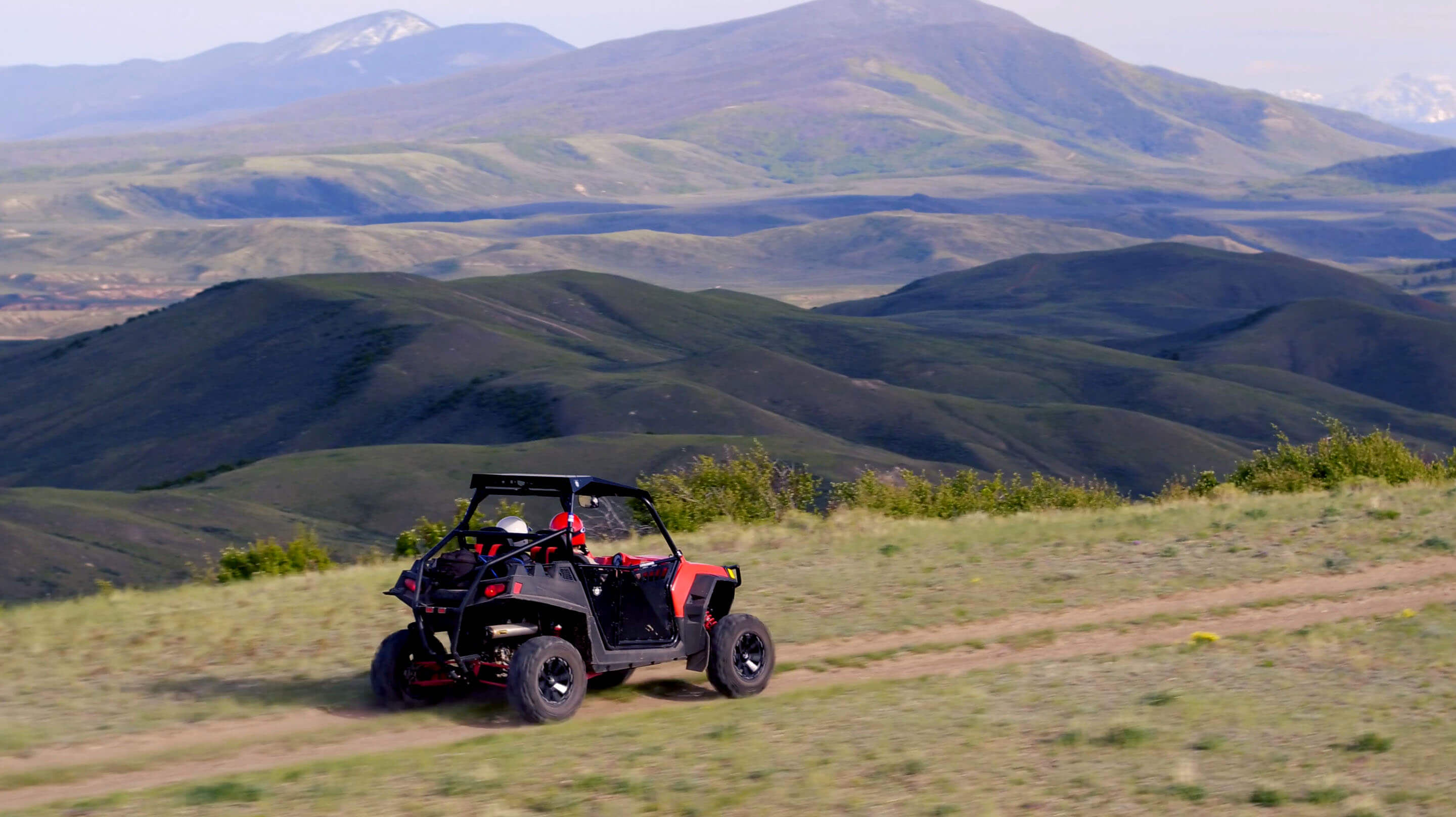 Black and red UTV with Colorado mountains in the background