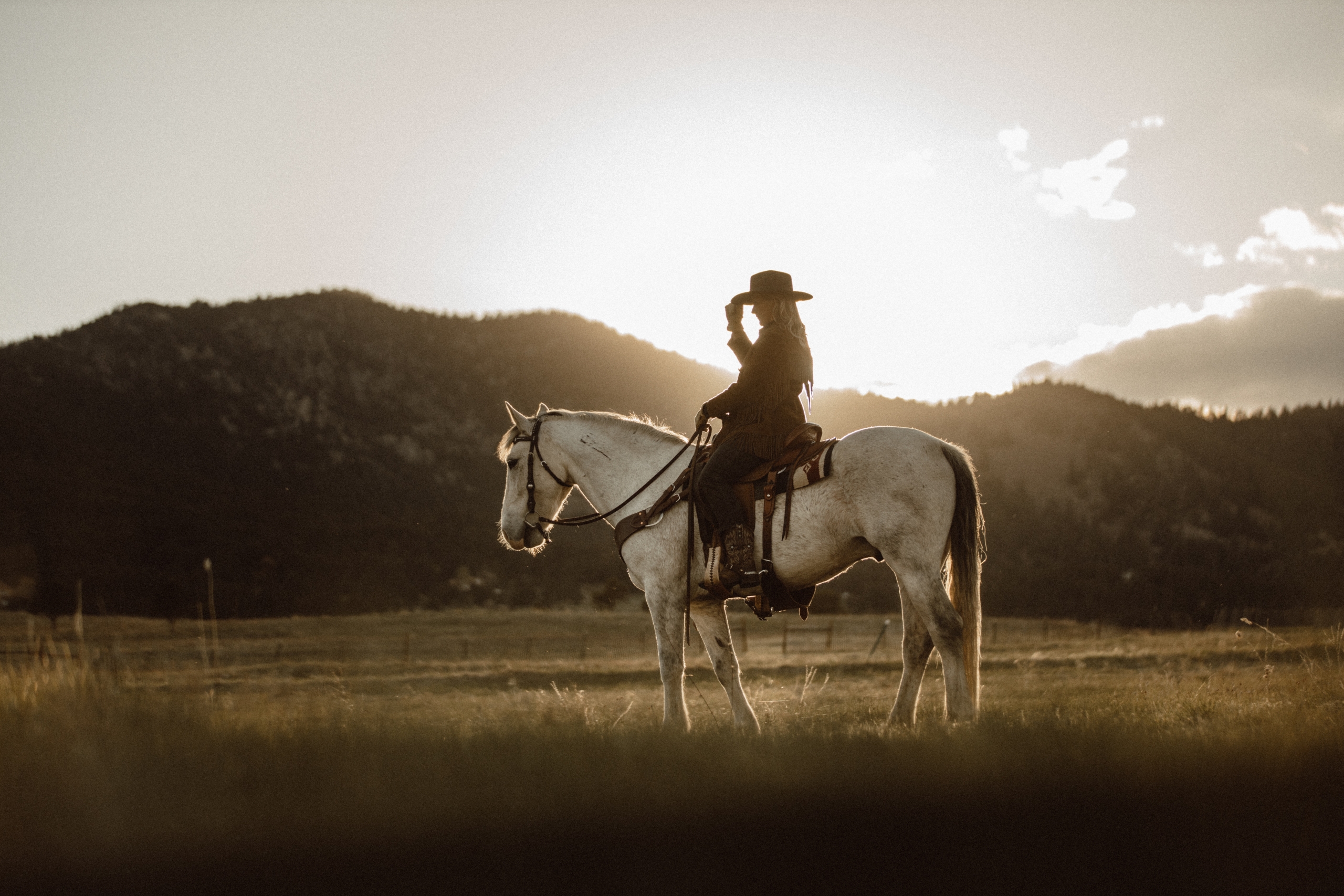 woman horseback riding in front of mountains