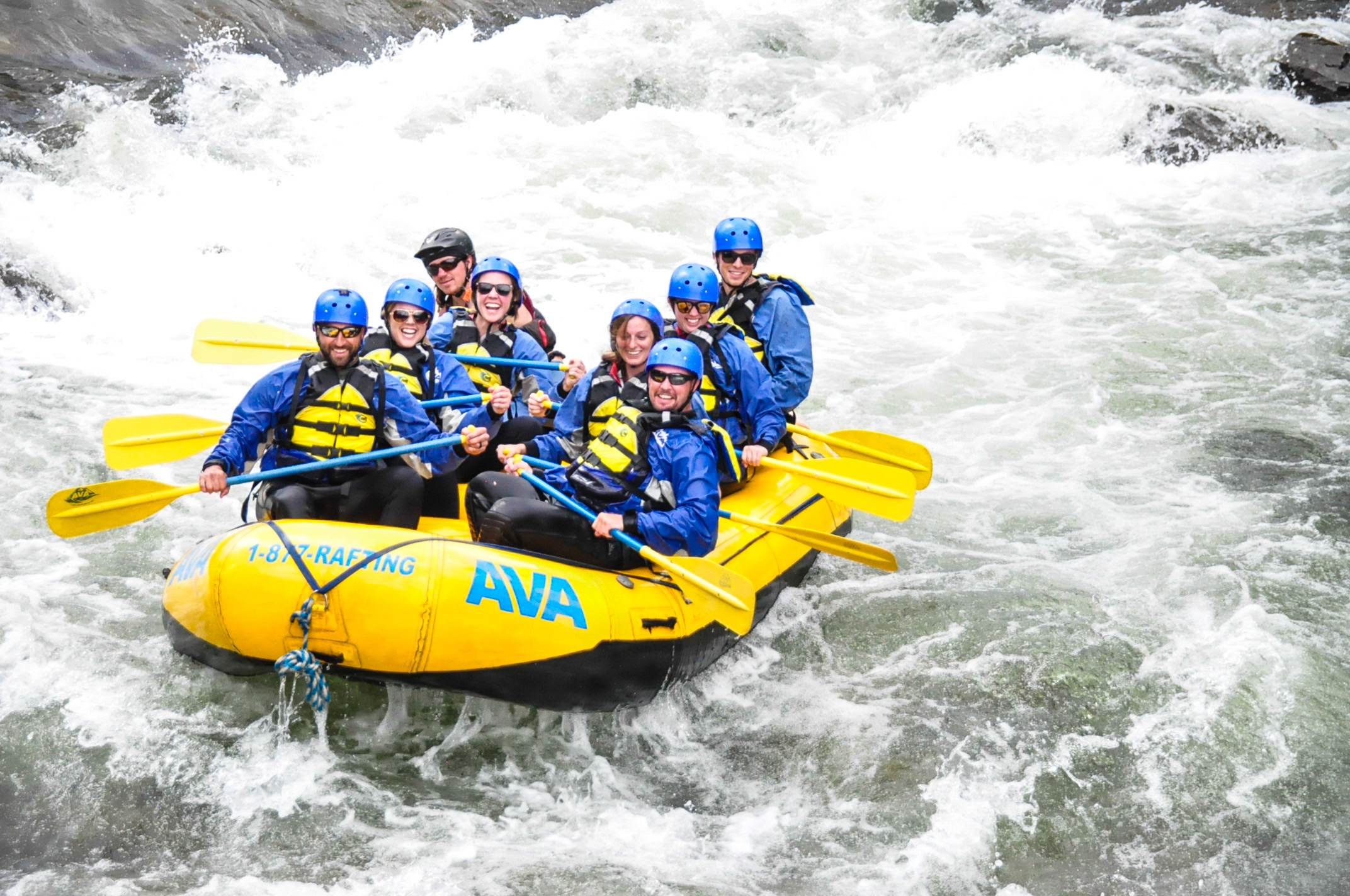 A group smiling while whitewater rafting