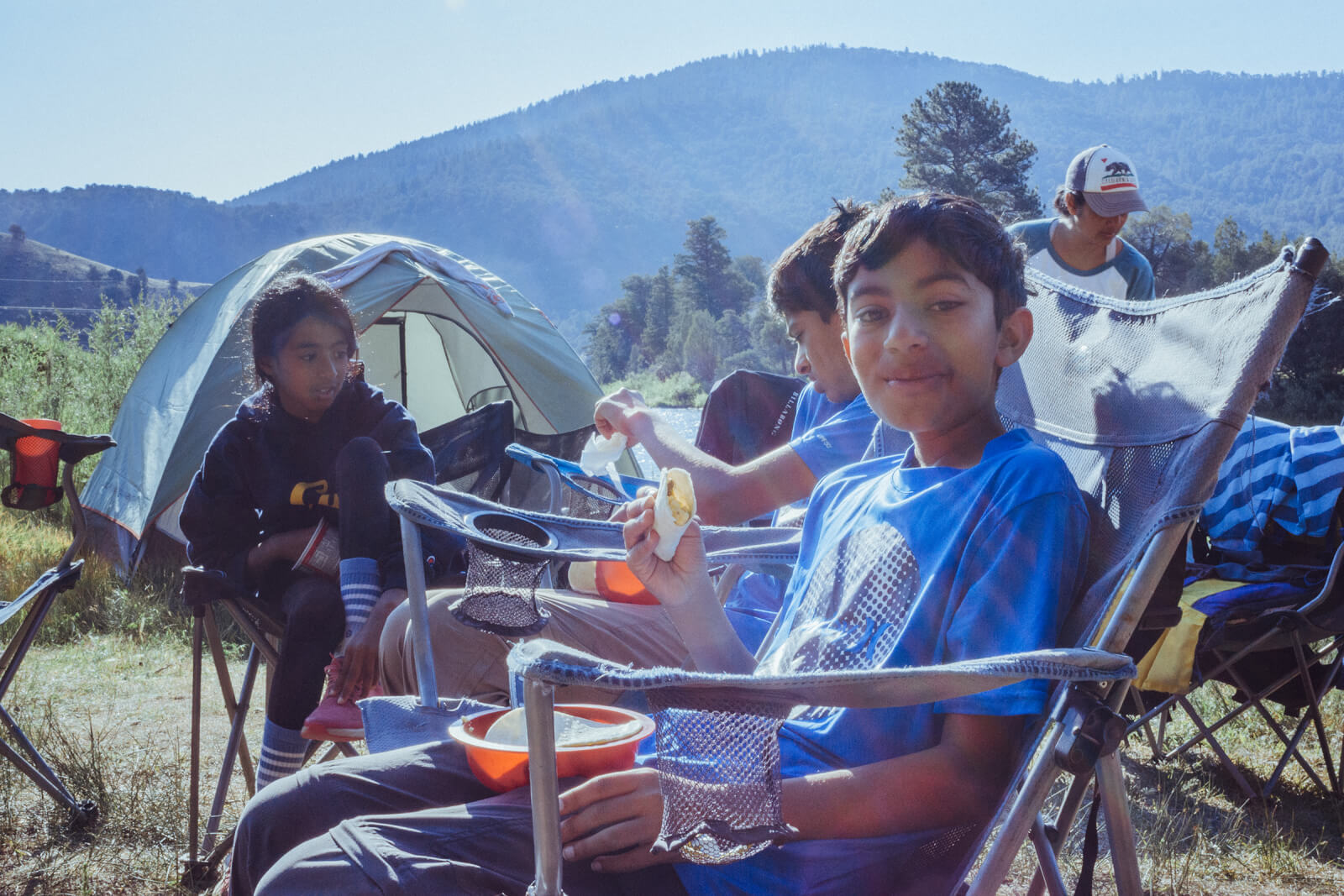 A group of siblings eating breakfast during an overnight whitewater rafting trip