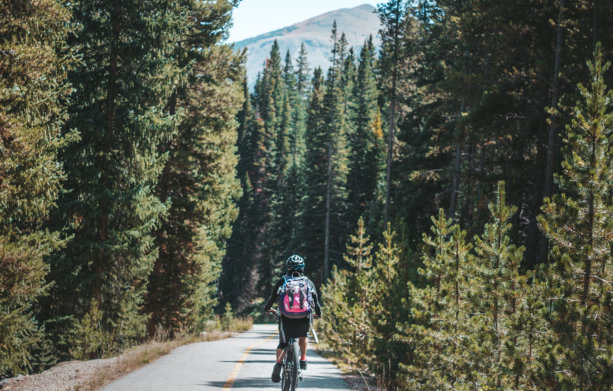 A girl with a pink back biking on a path in Idaho Springs, Colorado