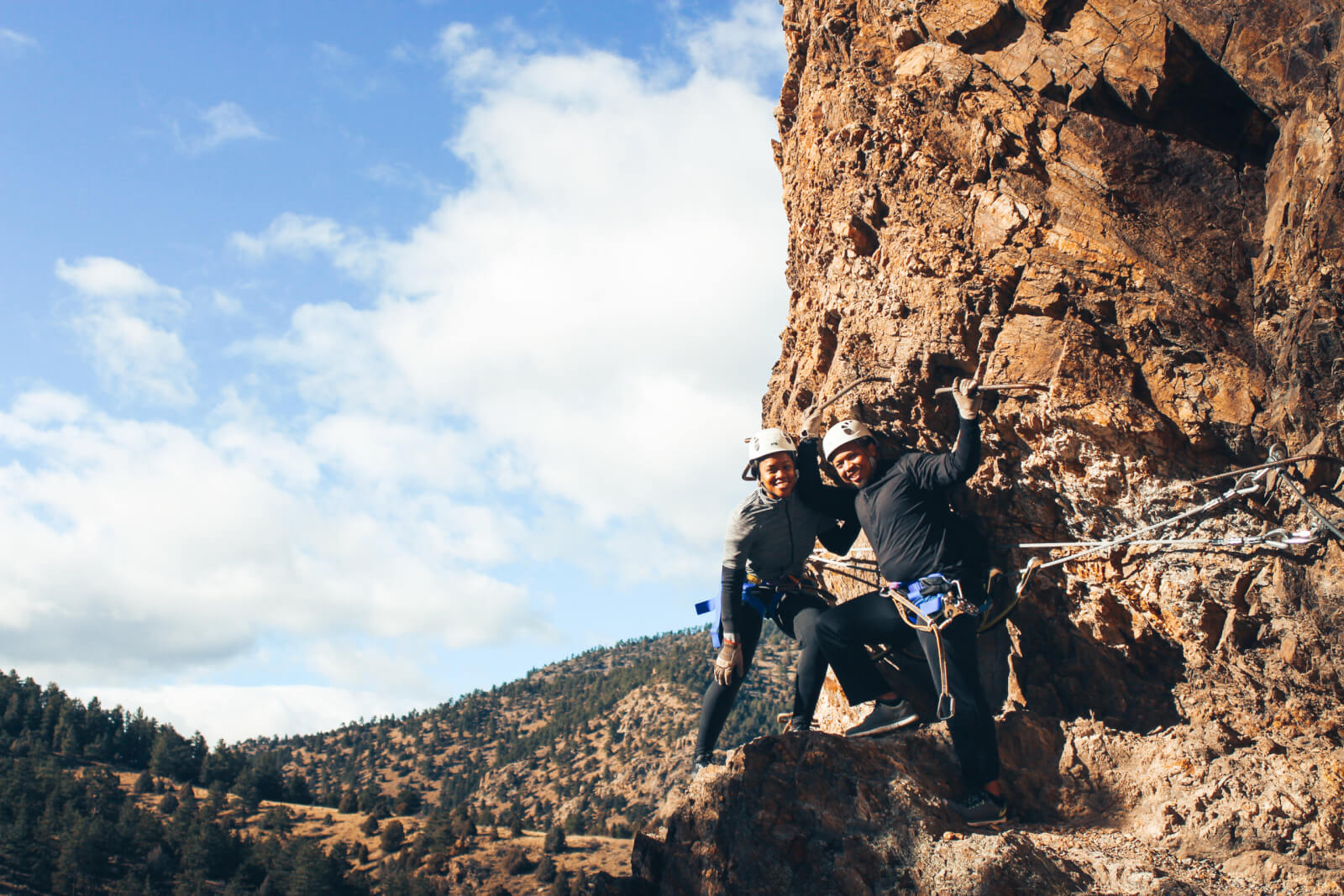 Two people posing for the camera while attempting the via ferrata in Idaho Springs