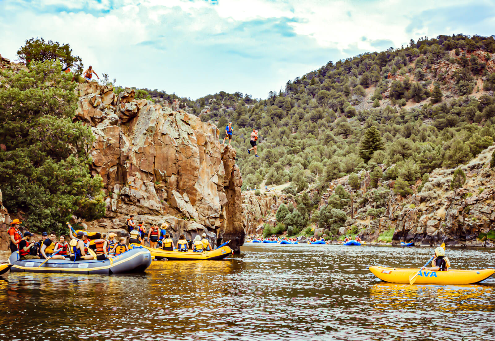 Rafting guests watching other guests jump from a cliff on the Colorado River in the Summer