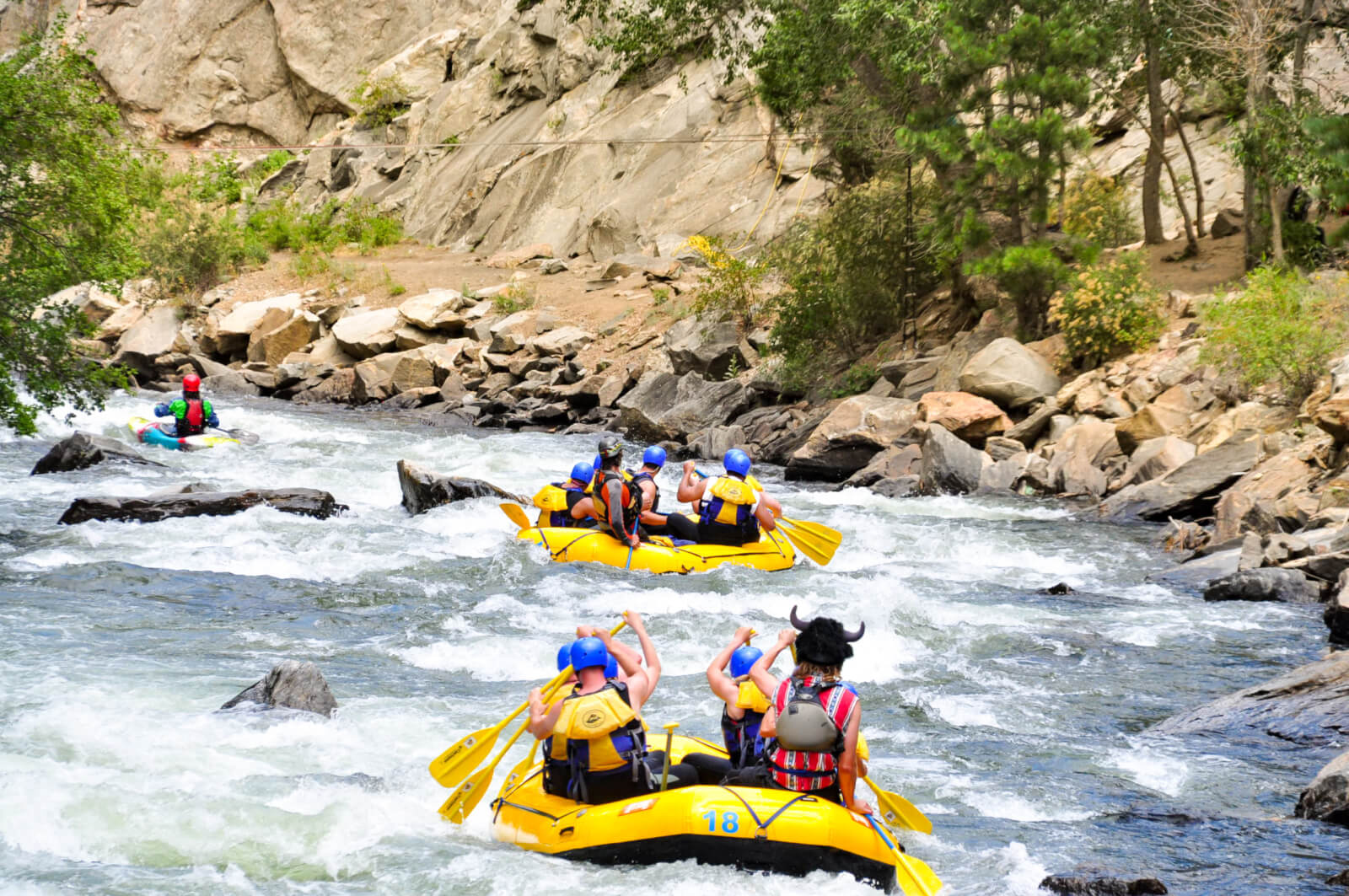 Large group rafting down through a canyon