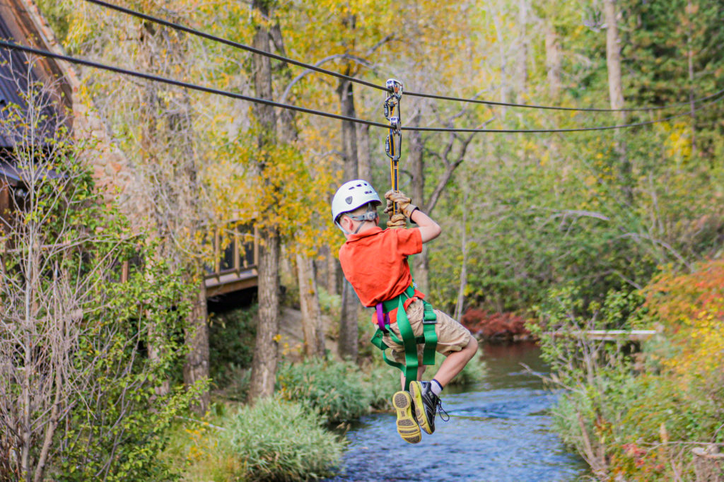 child ziplining over chicago creek in the fall