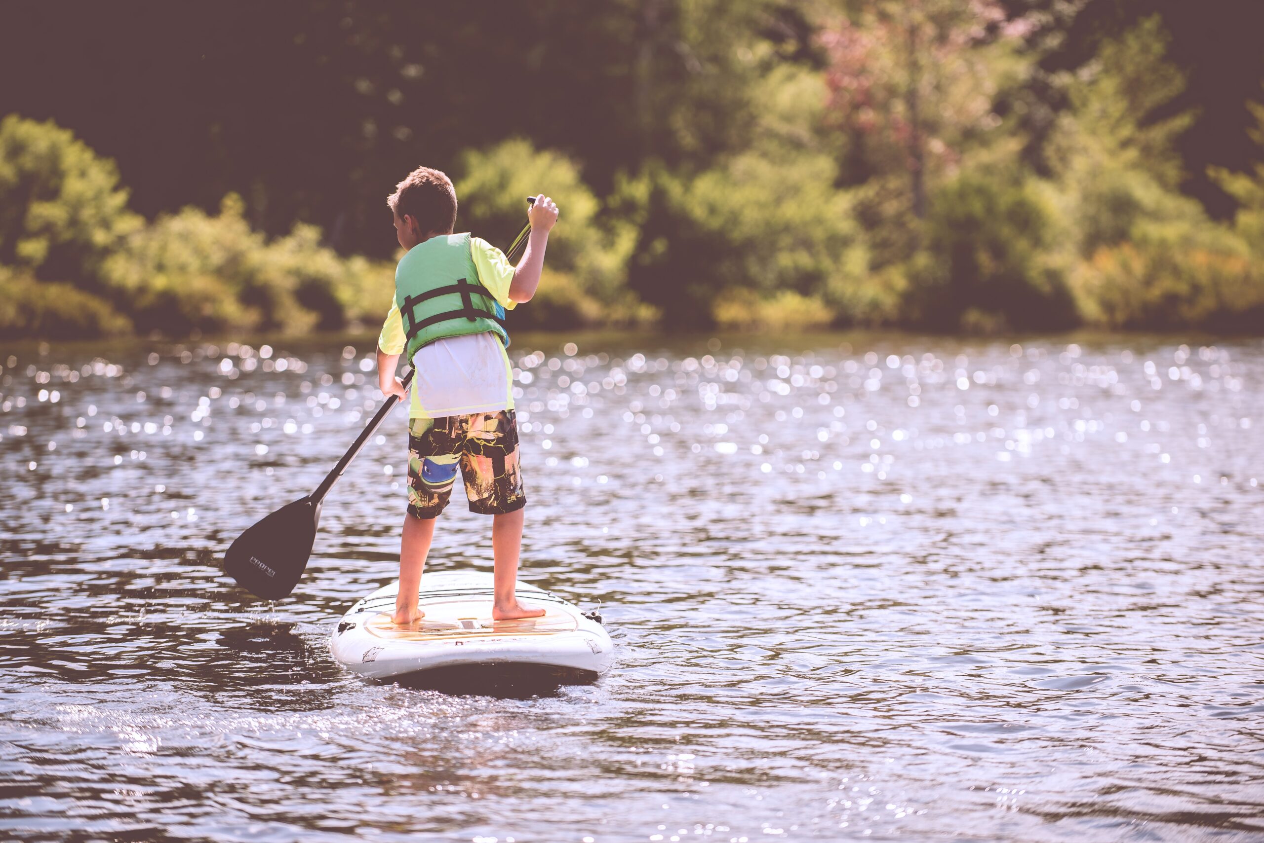 boy stand up paddleboarding