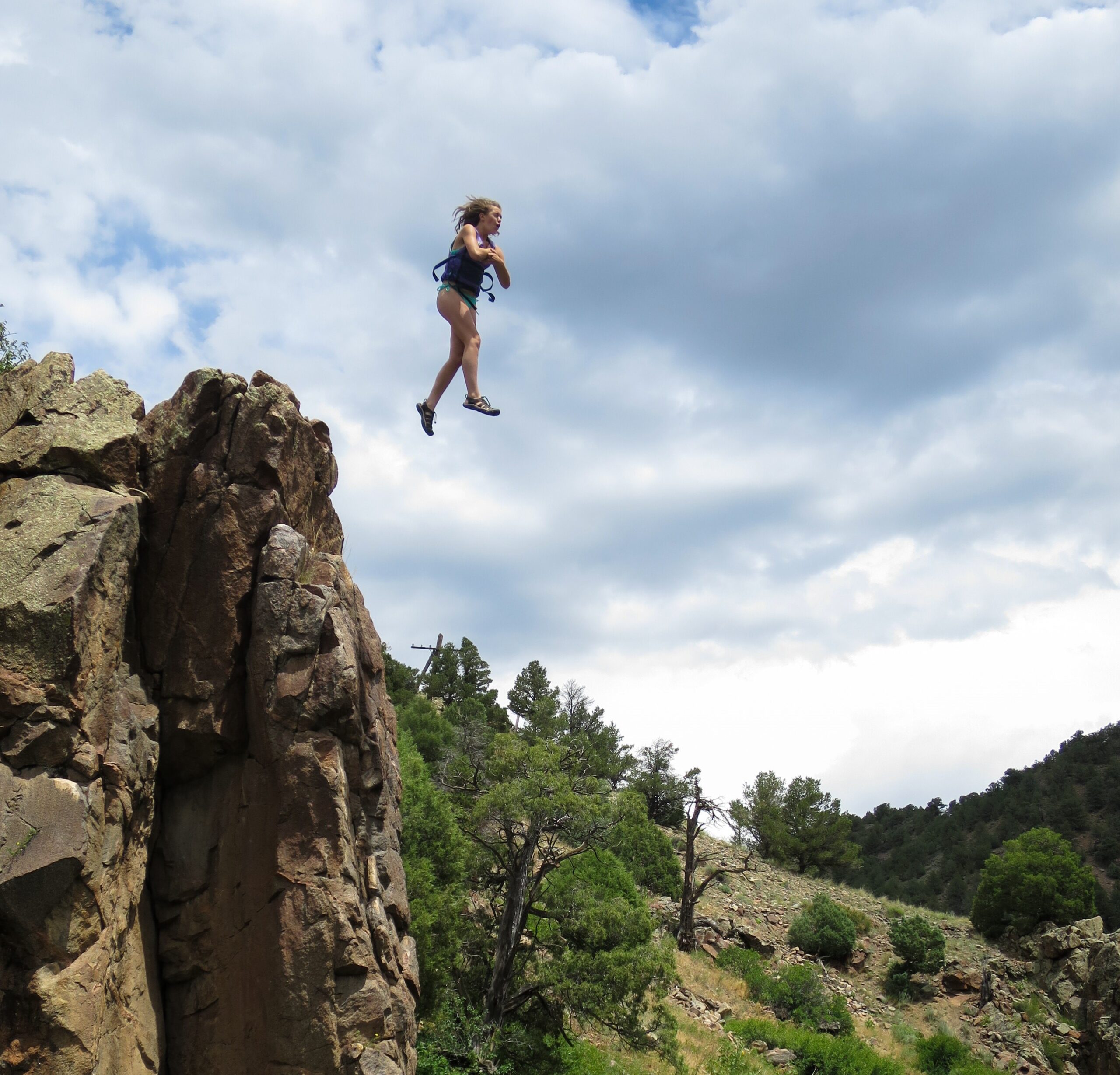 Girl jumping from rock