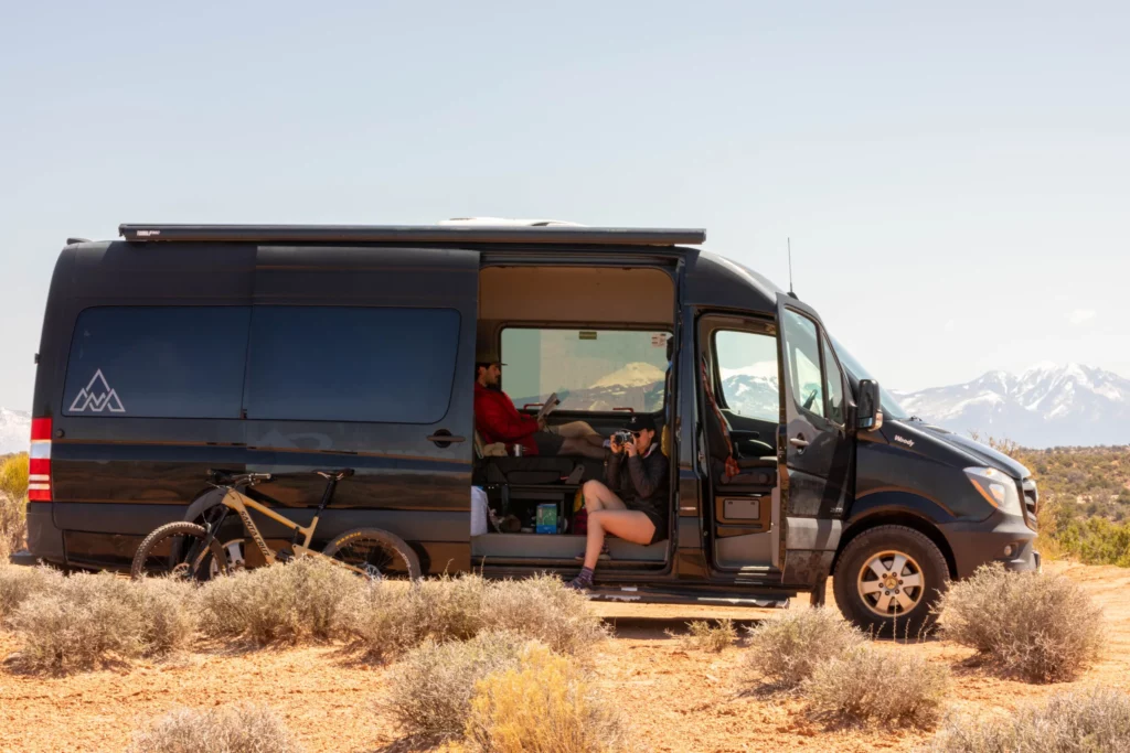 Woman sitting in a van and taking pictures near Buena Vista, Colorado.