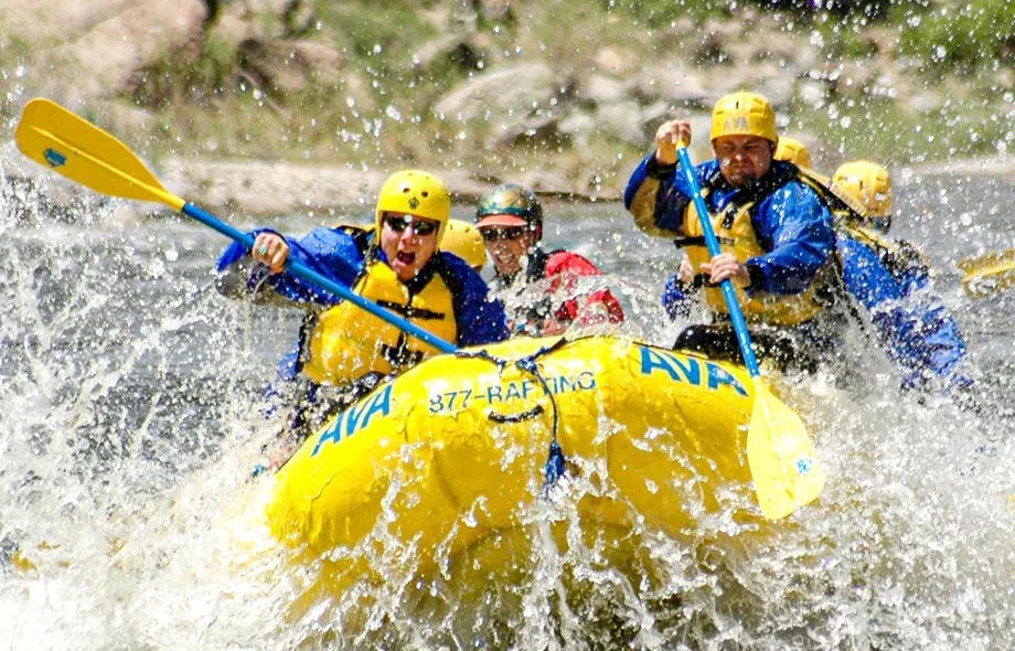 Group of rafters paddling through splashy white water on the Arkansas River.