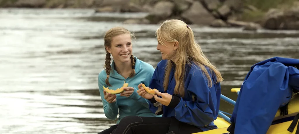 Young girls eating lunch during outdoor adventure.