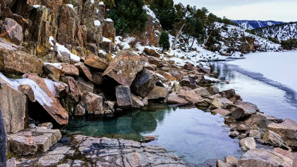 frozen lake and rocks lining the bank