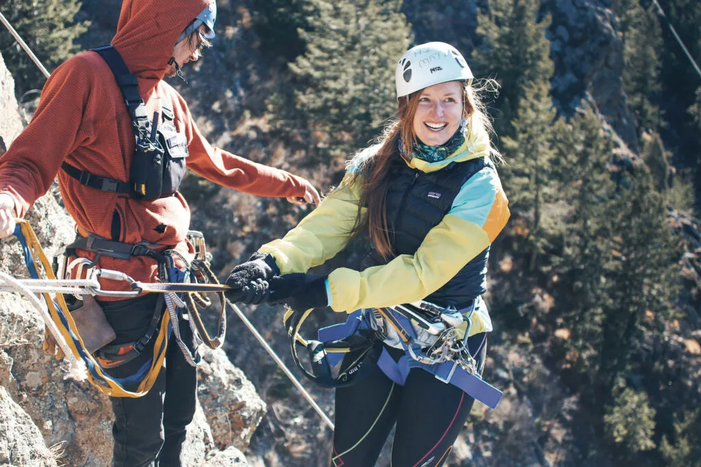 Woman smiling while traversing AVA's Mount Blue Sky Via Ferrata course