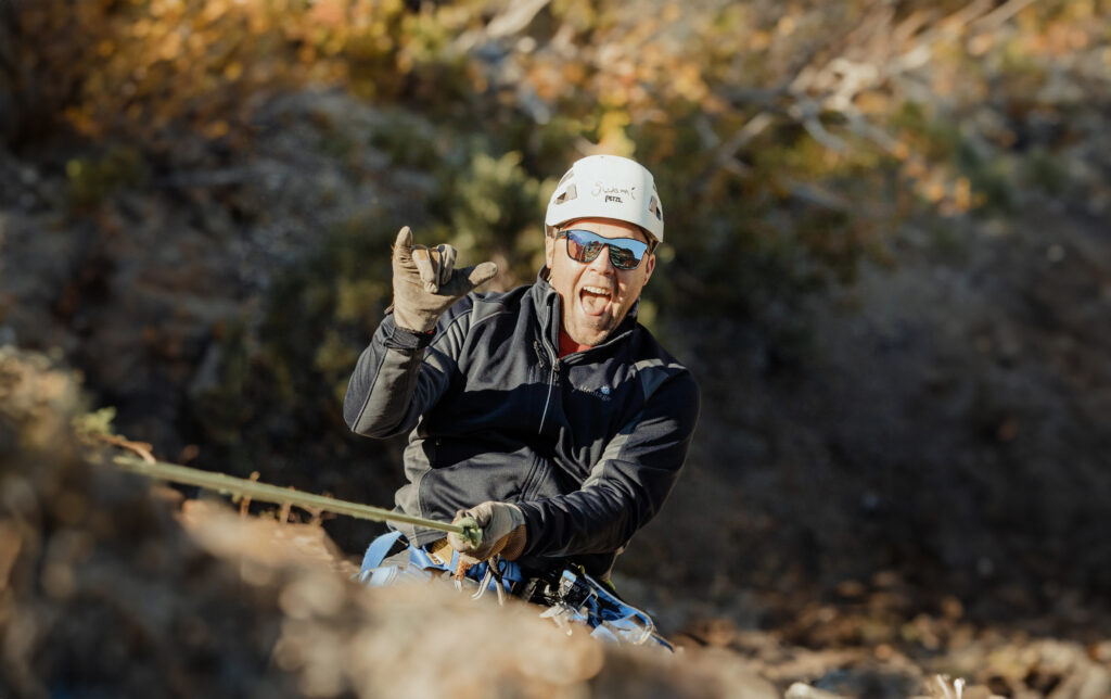 Man scaling mountain while rock climbing.