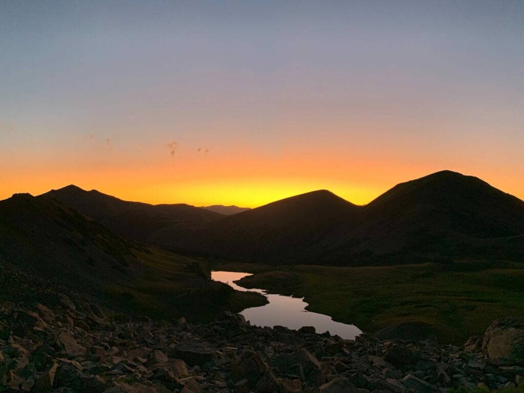 Mountain sunset with a river flowing through the center