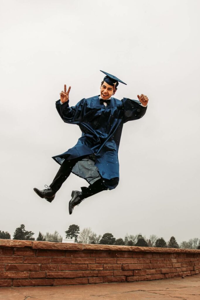 A kid who just graduated jumping in the air