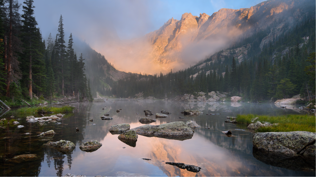 misty Colorado lake with Rocky Mountains in the background.