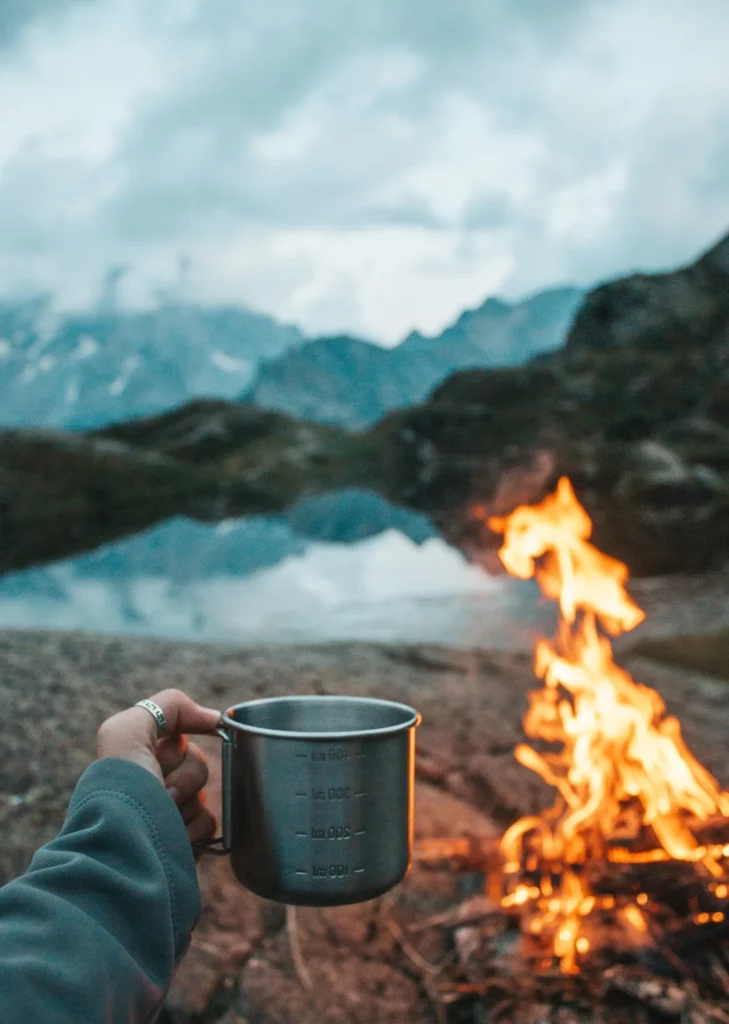 Enjoying coffee by campfire in the morning while on a raft trip in Colorado.