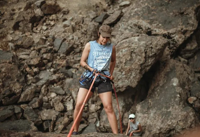 Woman tying knots before rock climbing in Colorado