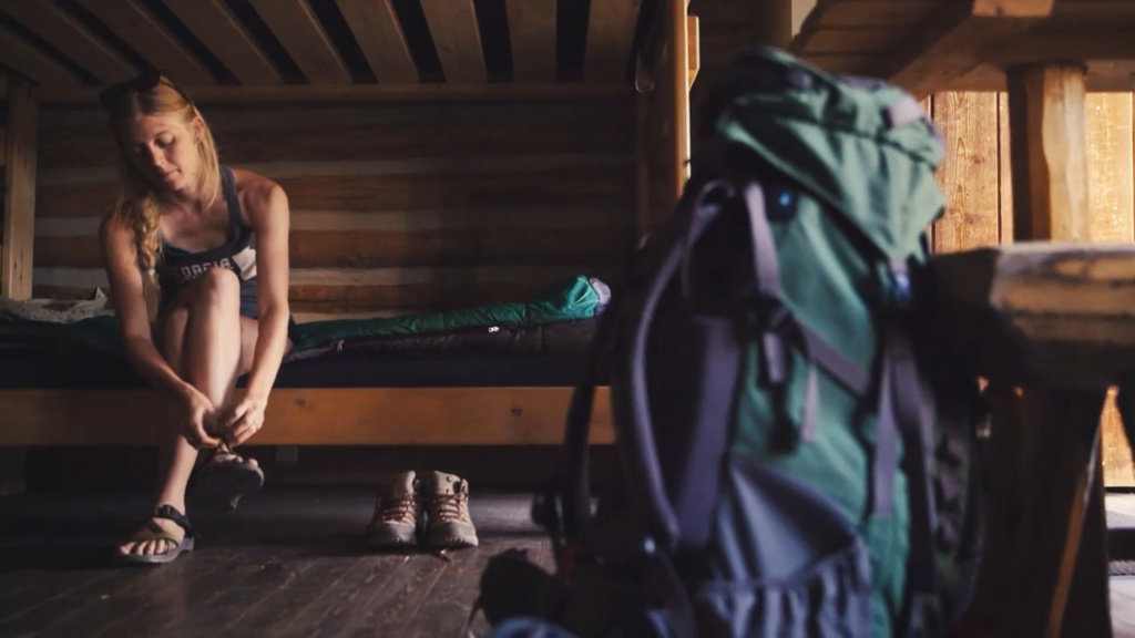 Woman getting ready for a day's adventure after spending the night in an AVA cabin.