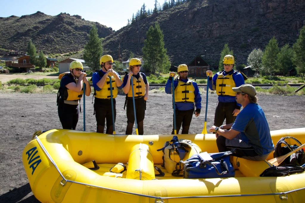 Group of rafters paying attention to the guide during safety instructions.