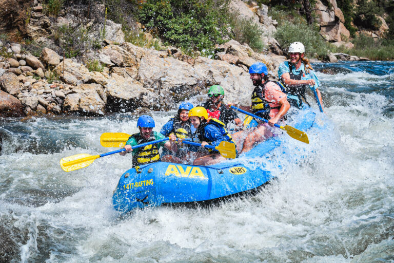 group smiling through spray as they paddle down the Arkansas River