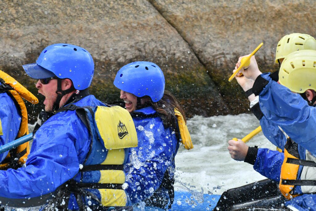 group heading into the rapids, man looking surprised and woman smiling