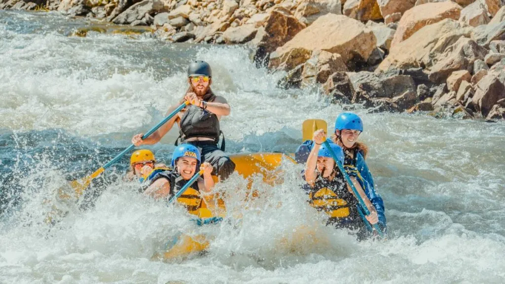 group rafting directly into whitewater spray