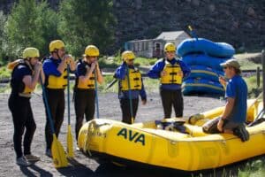 Guide sitting in a raft giving a run down of what to expect on Your AVA adventure