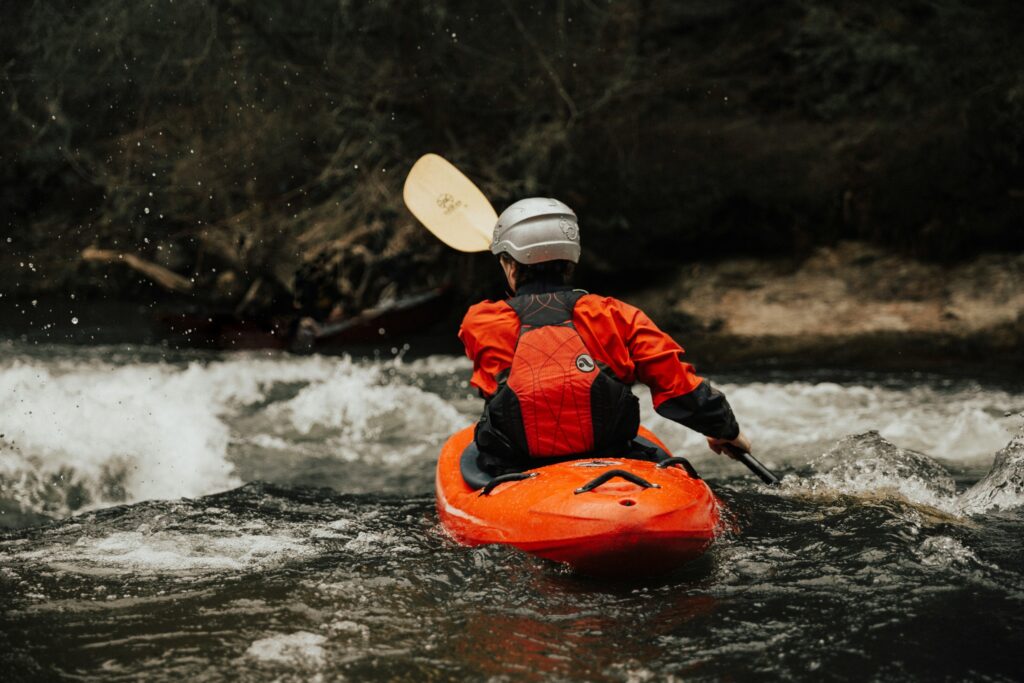 man kayaking through smaller waves