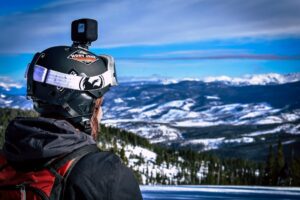 Man in Helmet With Action Camera Looking at Snow Mountain in Winter Park, Colorado