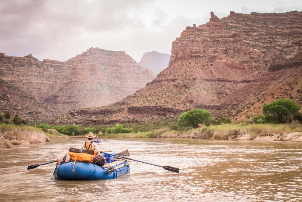 man rafting with gear down colorado river